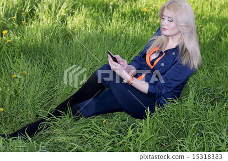 the beautiful girl on a grass with phone, a green grass the beautiful girl on a grass with phone, a green grass 15318383