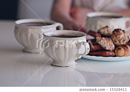 white cup of tea with cookies 15328411