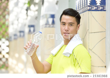Young Chinese man hydrating himself after exercise 15381988