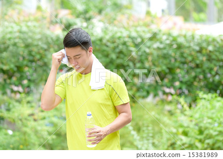Young Chinese man wiping sweat Young Chinese man wiping sweat 15381989