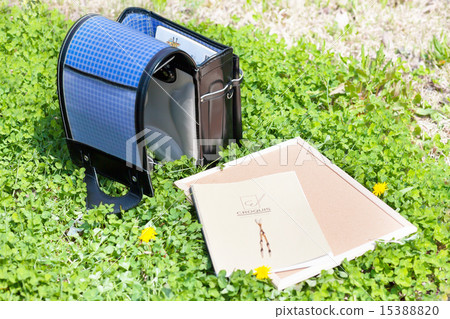 A school bag and a notebook placed on the fresh green grass A school bag and a notebook placed on the fresh green grass 15388820