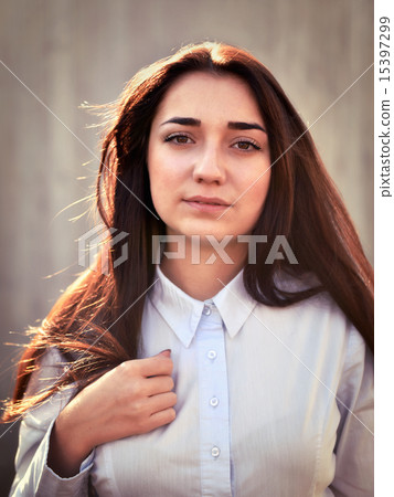 Portrait of a young pretty girl in a light shirt and with her ha Portrait of a young pretty girl in a light shirt and with her ha 15397299