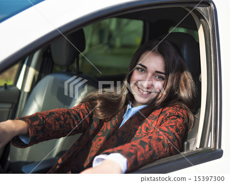 Young pretty smiling girl sitting behind the wheel of a car Young pretty smiling girl sitting behind the wheel of a car 15397300