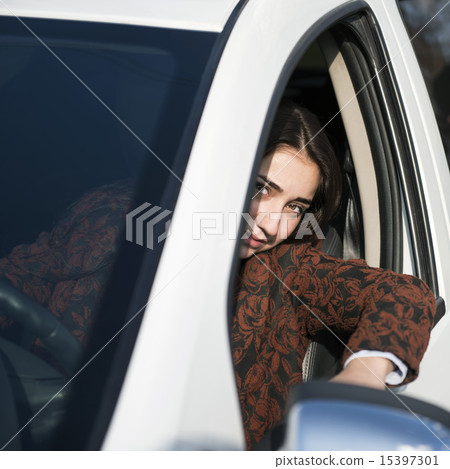 Young pretty smiling girl sitting behind the wheel of a car Young pretty smiling girl sitting behind the wheel of a car 15397301