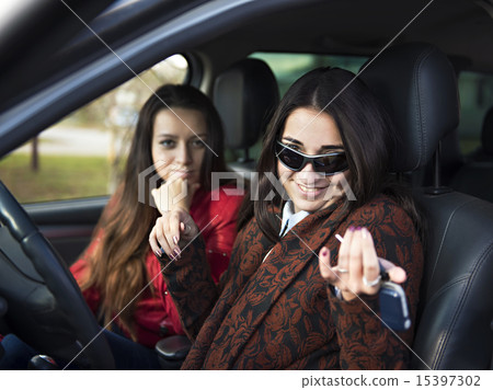 Two cute young smiling girl sitting in a car Two cute young smiling girl sitting in a car 15397302
