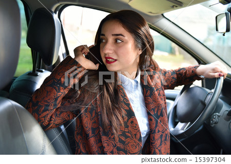 woman driving a car talking on the phone woman driving a car talking on the phone 15397304