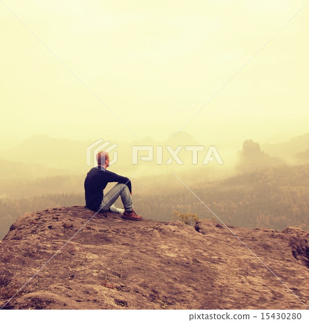 Tourist sit on peak of sandstone rock above gulch Tourist sit on peak of sandstone rock above gulch 15430280