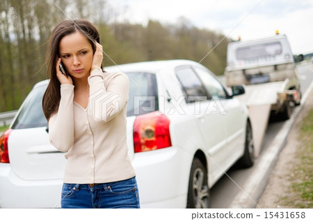 Woman calling while tow truck picking up her car 15431658