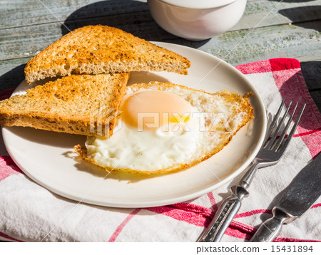 crispy toast with a fried egg and a cup of coffee 15431894