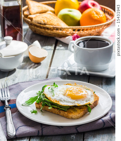 crispy toast with a fried egg and green arugula 15431943