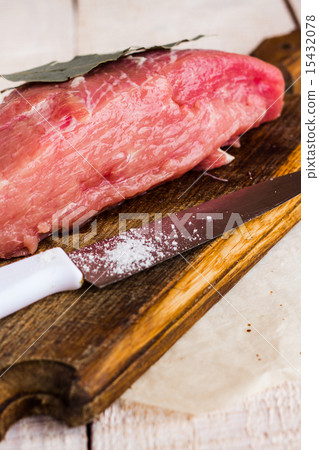 pork on a bay leaf, knife and salt on a wooden pork on a bay leaf, knife and salt on a wooden 15432078
