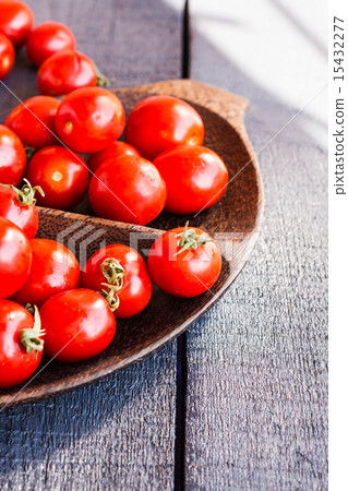 red juicy tomatoes cherry in brown wooden plate red juicy tomatoes cherry in brown wooden plate 15432277