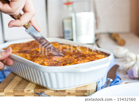cut meat lasagna in the form of baking, hands 15432560