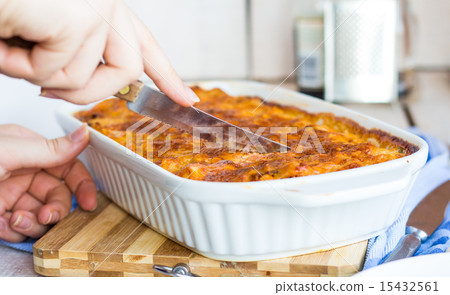 cut meat lasagna in the form of baking, hands cut meat lasagna in the form of baking, hands 15432561