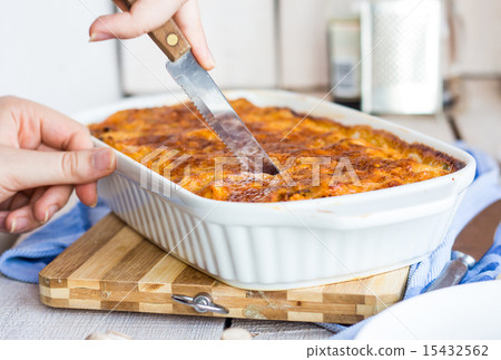 cut meat lasagna in the form of baking, hands cut meat lasagna in the form of baking, hands 15432562