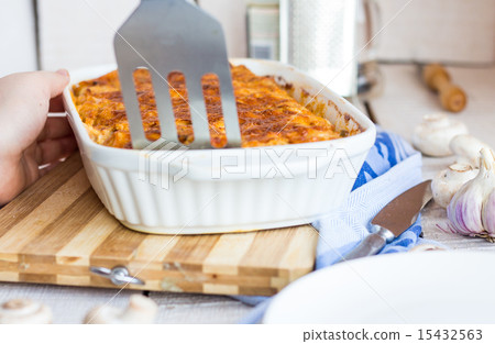 fed meat lasagna on a white plate, hand fed meat lasagna on a white plate, hand 15432563