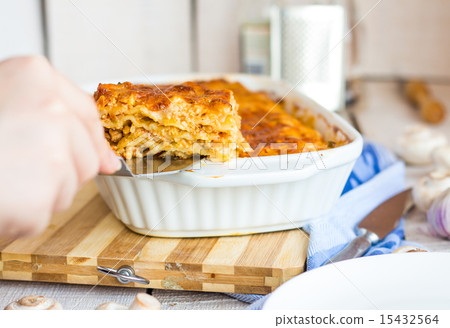 fed meat lasagna on a white plate, hand fed meat lasagna on a white plate, hand 15432564