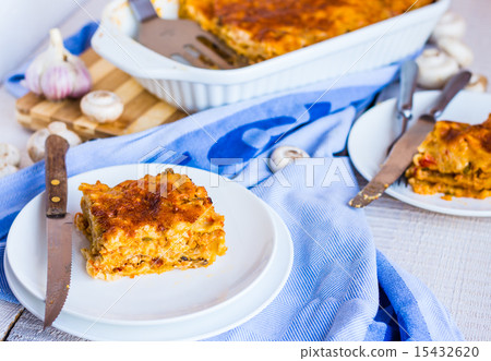 eating a piece of meat lasagna with mushrooms 15432620