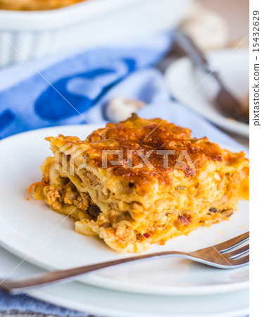 eating a piece of meat lasagna with mushrooms 15432629