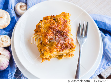eating a piece of meat lasagna with mushrooms 15432632