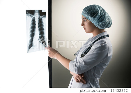 Image of attractive woman doctor looking at x-ray results Image of attractive woman doctor looking at x-ray results 15432852