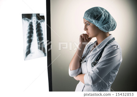 Image of attractive woman doctor looking at x-ray results Image of attractive woman doctor looking at x-ray results 15432853