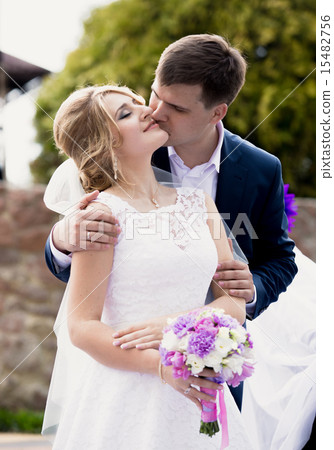 handsome groom giving a kiss on brides cheek handsome groom giving a kiss on brides cheek 15482756