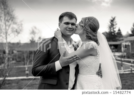 portrait of bride giving a kiss on grooms cheek 15482774