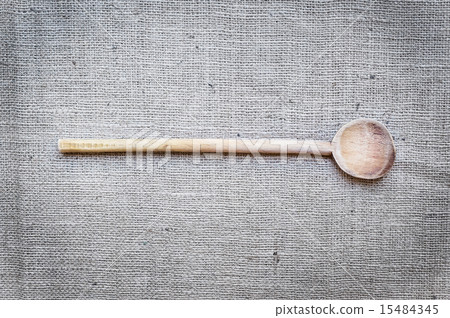 Rustic wood cooking spoon on a sackcloth surface 15484345