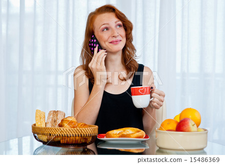attractive girl with freckles eating breakfast 15486369