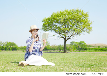 A woman using a tablet outside 15487998