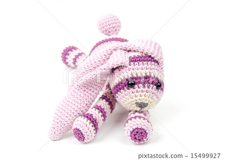 Knitted pink rabbit toy lays isolated on white 15499927