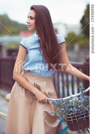 Beautiful, elegantly dressed woman with bicycle Beautiful, elegantly dressed woman with bicycle 15499998