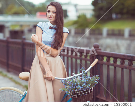 Beautiful, elegantly dressed woman with bicycle Beautiful, elegantly dressed woman with bicycle 15500001