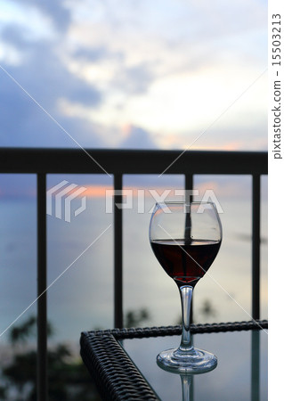 在黃昏時在海灘邊的露台上喝紅酒 15503213