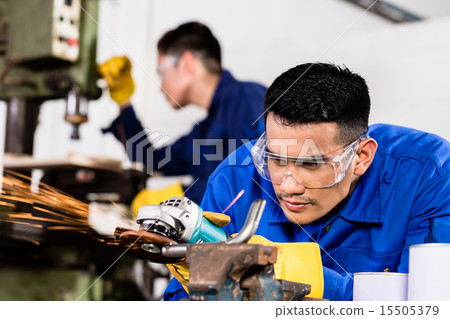 Metal workers in industrial workshop grinding 15505379