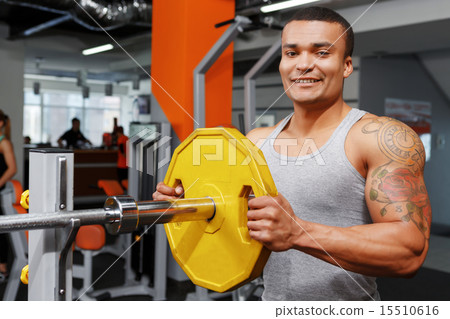 Young man preparing his barbell. Young man preparing his barbell. 15510616