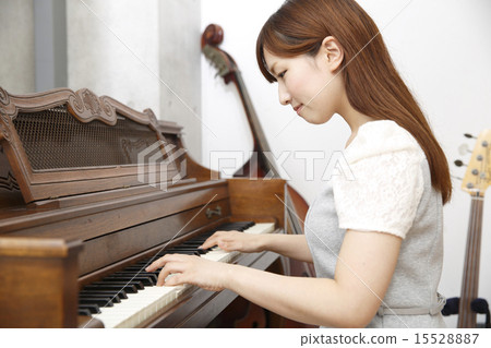 A young lady playing a piano 15528887