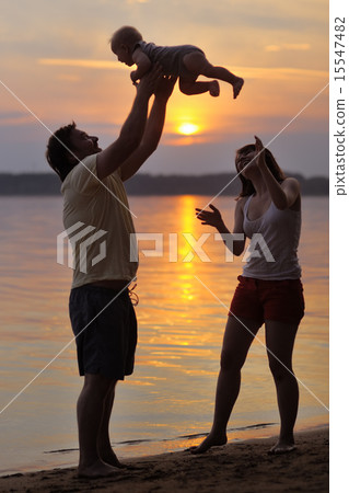Happy family of three on the beach 15547482