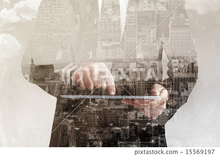 Composite image of businessman using his tablet pc 15569197