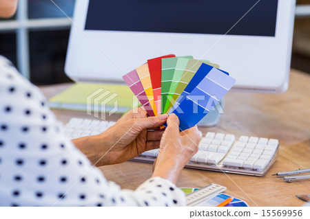 Casual businesswoman looking at colour swatch Casual businesswoman looking at colour swatch 15569956