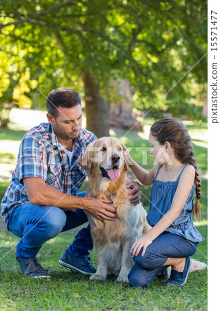 Father and daughter with their pet dog in the park Father and daughter with their pet dog in the park 15571477