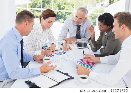 Business team analyzing bar chart graphs 15571715