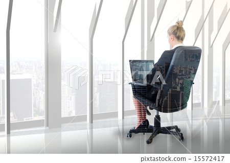 Composite image of businesswoman sitting on swivel chair with la 15572417