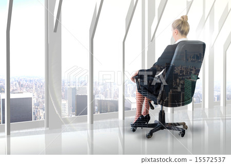 Composite image of businesswoman sitting on swivel chair in blac 15572537