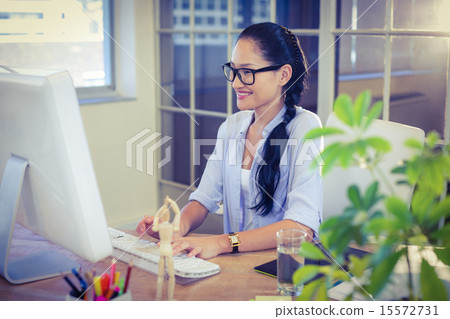 Happy young designer working at desk 15572731