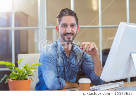 Casual businessman holding glasses and smiling at camera Casual businessman holding glasses and smiling at camera 15573653