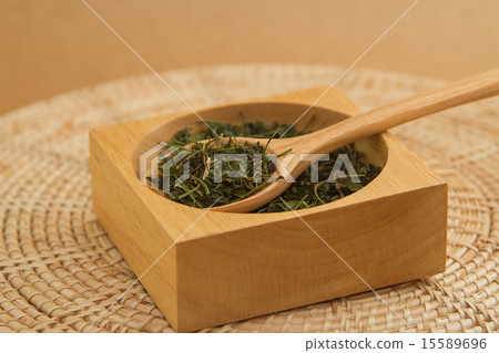 Dry green tea leaves in wooden spoon  15589696