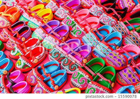 Hand-made baby shoes on red background. 15590078