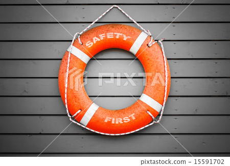 Safety first. Red lifebuoy hanging on gray wall 15591702